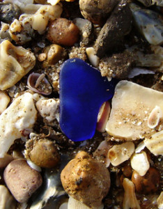 blue sea glass on pebbles